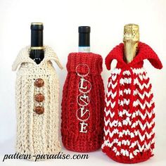 three crocheted wine bottles are lined up next to each other, one is red and the other is white