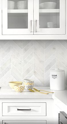 a kitchen with white cabinets and yellow dishes on the counter