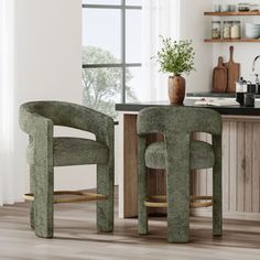 two green chairs sitting next to each other in front of a kitchen counter with an open window