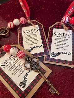 two tags are attached to key chains on a red table with other items and decorations