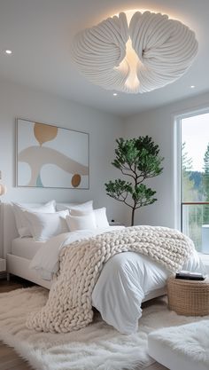 a bedroom with white bedding and pillows on the floor next to a large window