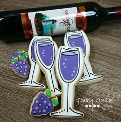 two decorated wine glasses with strawberries on them and a bottle of wine in the background