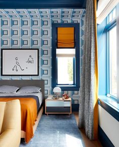 a bedroom with blue walls and orange curtains