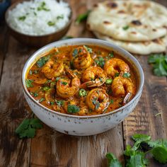 a bowl filled with shrimp and rice next to pita bread