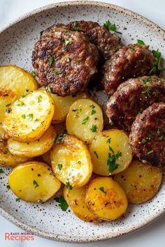 a white plate topped with potatoes and meatballs