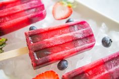 popsicles with blueberries and strawberries on ice