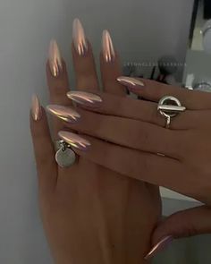 a woman's hand with some shiny nails and rings on her fingers in front of a mirror