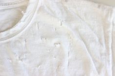 a white t - shirt with holes on it