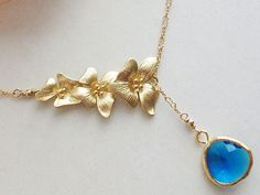 "Eye Catching 14k Gold Filled Lariat style Necklace in combination with triple orchids and Gold framed Royal Blue Glass Stone look Very Elegant! Uniquely designed and handcrafted by \"AnnTig\". Materials used: 14k Gold Filled chain, 14k Gold Filled wires, 14k Gold filled clasp, the triple orchid detail is gold plated (15x30mm), blue gold framed glass stone (13x16mm) Details: Brand New Necklace Measures approx. 18\"L. Gift Box included" Pearl Wedding Jewelry Sets, Orchid Necklace, Lariat Style Necklace, Simple Silver Jewelry, Silver Wedding Jewelry, Pearl Jewelry Wedding, Jewelry Post, Amber Earrings, Amber Bracelet