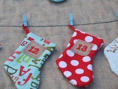 three stockings hanging from clothes pins with numbers on them and polka dot fabric in the background