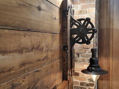 an old fashioned light is hanging on the side of a brick wall next to a wooden door