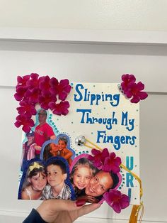 a person holding up a sign with flowers on it that says shipping through my fingers