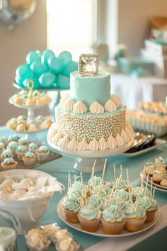 a table topped with lots of cupcakes and cakes