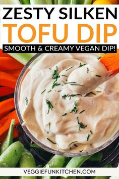 a bowl filled with cream cheese dip surrounded by carrots and celery