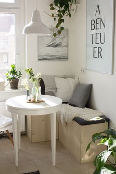 a living room with a couch, table and potted plants