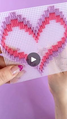 someone is holding up a card with a heart on it and the video appears to be made out of yarn