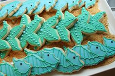 decorated cookies in the shape of sea creatures on a platter with blue icing