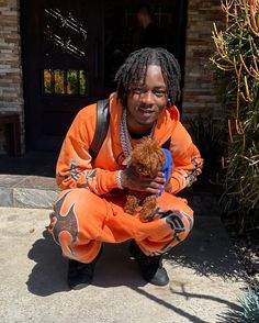 a man in an orange outfit holding a dog