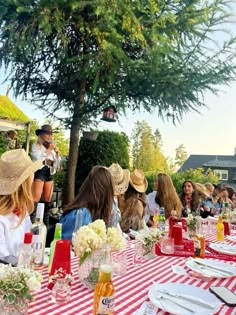 a group of people sitting around a red and white table