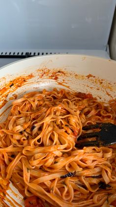 a pan filled with pasta and sauce on top of a stove