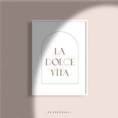 a poster with the words la dolce vita in gold foil on a beige wall