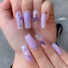 someone is holding up their nails with butterflies on them