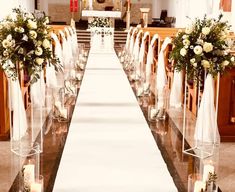 the aisle is decorated with flowers and candles