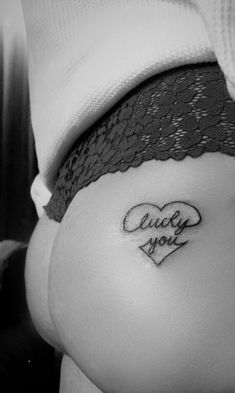 a woman's stomach with the word juicy you tattooed on it and a heart