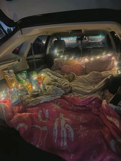 the back end of a car with blankets and lights in the bed area on it