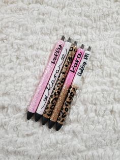 three pens with writing on them sitting on a white surface