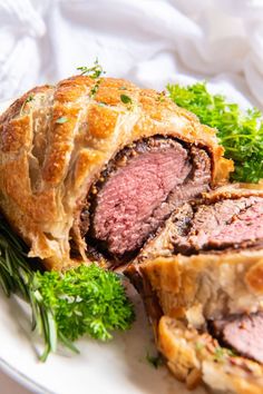 a meatloaf roll on a white plate with parsley sprig around it