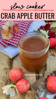 an apple butter recipe in a glass jar with apples around it and flowers on the table