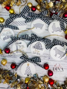 christmas ornaments are arranged on a white wooden surface with gold and red decorations around them