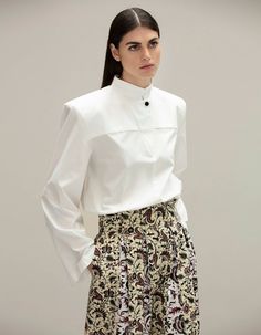 White as the iceberg, this blouse has very refined cuts and a perfect fit. This makes it so easy to mix and match with all the other items of the collection and to wear it in any occasion that requires a bit of sophistication Chic Formal Blouse With Set-in Sleeves, Chic Formal Top With Set-in Sleeves, White Top For Office Wear In Fall, White Tops For Office Wear In Fall, Chic Long Sleeve Tops For Semi-formal Occasions, White Padded Blouse For Office, Modern Formal Blouse For Fall, White Long Sleeve Modern Blouse, Elegant Fall Tops With Set-in Sleeves