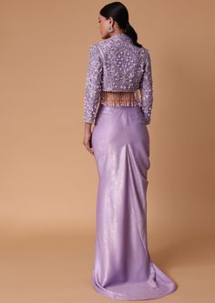 Introducing our mesmerizing lilac draped skirt ensemble a glamorous amalgamation of elegance and contemporary charm. Detailed with a gathered front foil prints and thigh-high slit it is complemented with a chic tassel jacket. Adding a touch of flair and versatility are the delicately embellished cutdana beads pearls and hanging tassels. Whether it's a special occasion or a glamorous evening affair this ensemble will help you embrace the essence of modern femininity and timeless beauty. Dry clean only if required. Slight variation in color is possible due to digital photography. Drape Skirt With Jacket, Skirt With Jacket, Hanging Tassels, Tassel Jacket, Foil Prints, Indian Kurti Designs, Indian Kurti, Draped Skirt, Nice Things