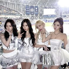 four girls in white outfits posing for the camera