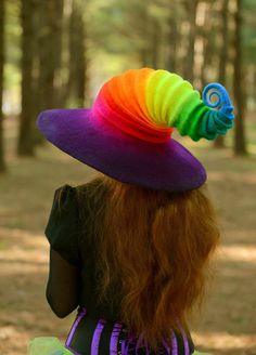 a woman wearing a colorful hat in the woods