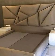 a bed that is made up and has some lights on top of the headboard