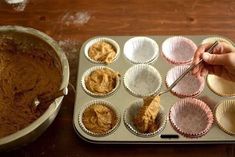 a person is making cupcakes in a muffin tin