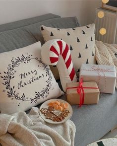 a couch covered in christmas gifts and presents next to a candy cane on top of a pillow