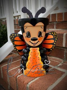 a paper mache butterfly sitting on top of a brick wall next to a stair case