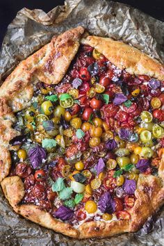 a pizza covered in lots of toppings on top of tin foil