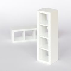 a white book shelf sitting on top of a table next to an open box with compartments