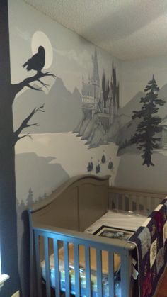 a baby's room with a castle mural on the wall and a crib