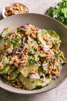 a bowl filled with cucumbers and chopped nuts