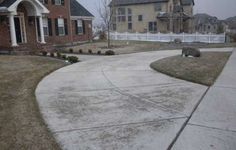 an empty driveway in front of some houses