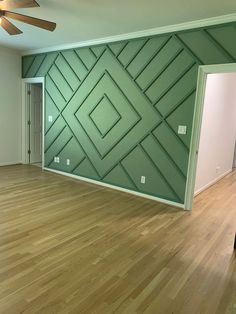 an empty room with hard wood floors and green walls