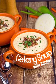 two orange bowls filled with soup sitting on top of a wooden table next to carrots