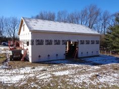 two garages are shown with snow on the ground and trees in the backgroud