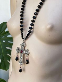 Large Baroque cross pendant necklace. Chain is 12 mm faceted black glass with 4 mm spacers. The Centre of the cross has red Swarovski Crystal colour Ciam. Cross is zinc alloy. Cross-shaped Faceted Beads For Jewelry Making, Black Crystal Pendant Necklace, Black Crucifix Jewelry For Jewelry Making, Black Beaded Crucifix Jewelry, Black Cross Pendant Necklace For Party, Black Cross Pendant Necklaces For Party, Necklace With Black Stone, Wedding Jewellery Necklace, Red Crystals